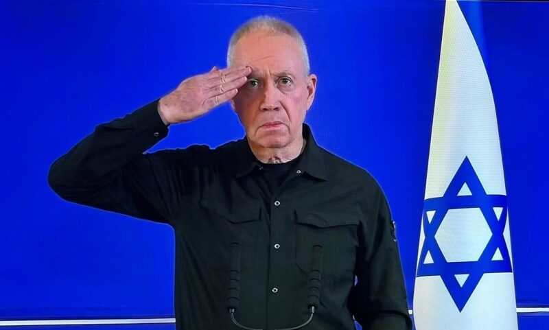Outgoing Defense Minister Yoav Gallant salutes at the end of his speech following his dismissal