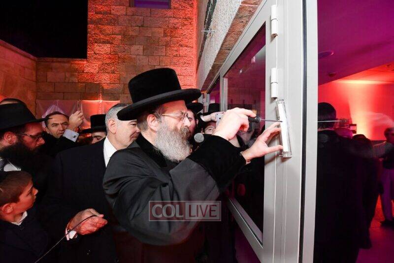 The Sadigura Rebbe affixes a Mezuzah during the Colel Chabad inauguration of the Eleanor and Ronnie Cohen Building in Jerusalem