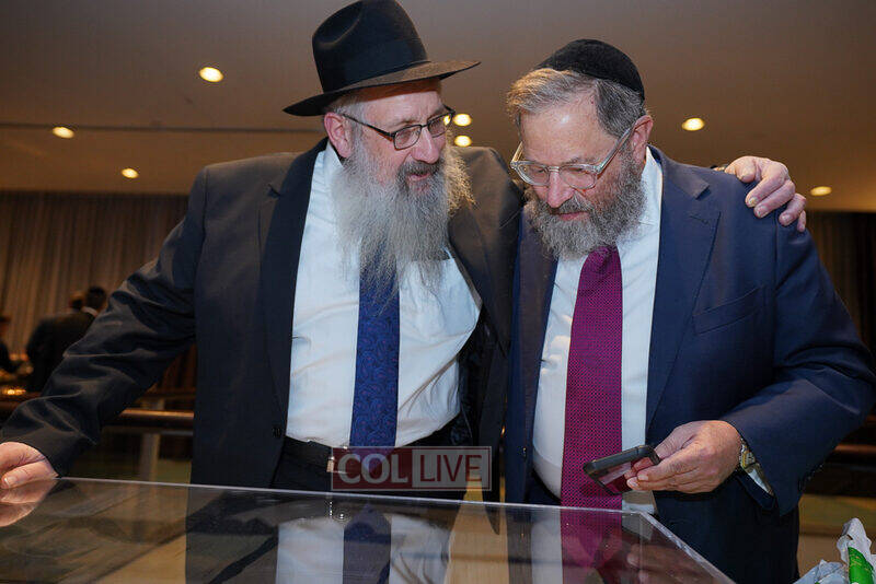 R' Tuvia Schottenstein looking at the archives of Colel Chabad with Rabbi Sholom Duchman at the dinner this past December