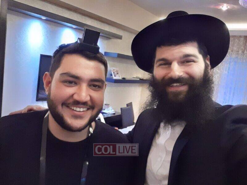 Rabbi Nakhshon Yunaev helping a Jewish man with Tefillin