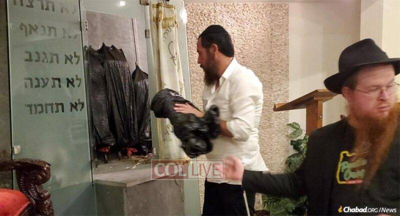 Volunteers at the Chabad Center of Metairie safeguard the Torah scrolls as Hurricane Ida approaches.<br />
