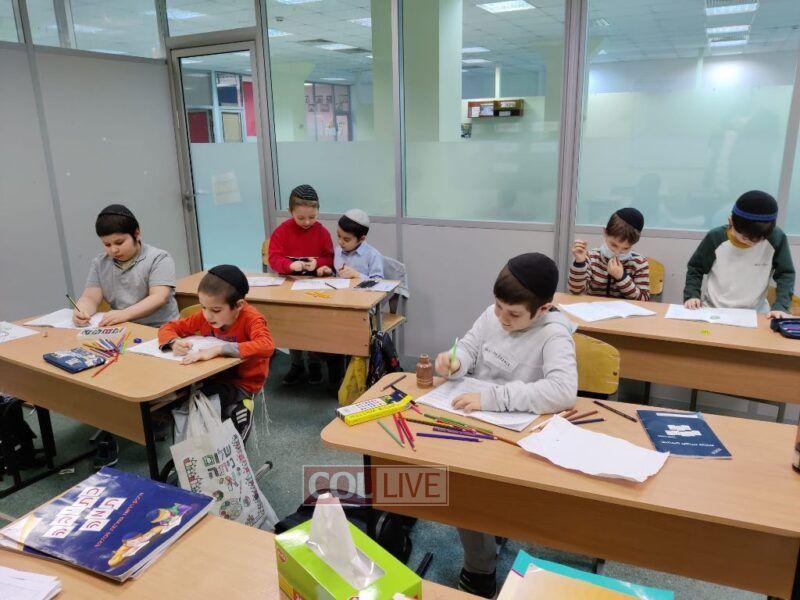 Yoel Dovid, second from left in the orange shirt, at school