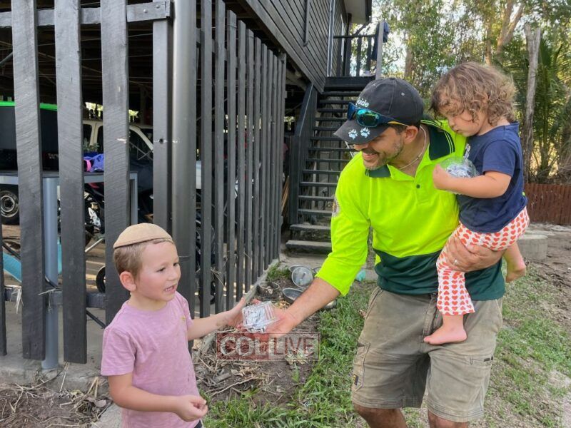 Shlomo Rubin giving care packages to displaced Jews in Cairns<br />
