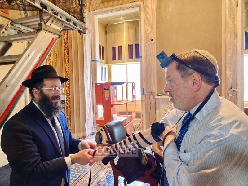 Rabbi Mendy Deitsch assists a man with putting on Tefillin during his visit to the senate