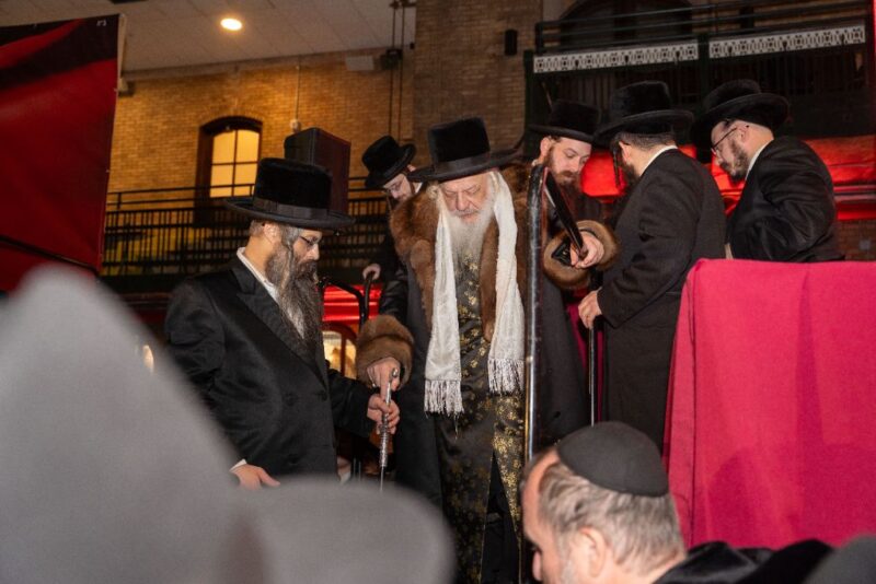 Chernowitz Rebbe leaving the Siyum Harambam with his son Rabbi Avrohom Sholom Schneebalg<br />
<br />
